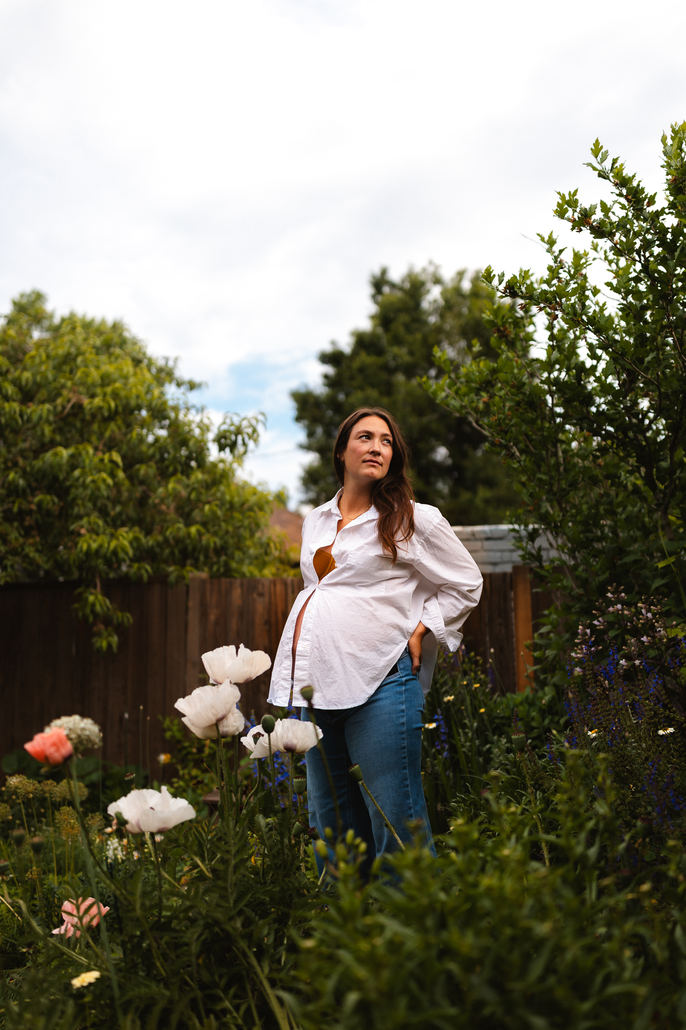 denver based maternity photographer photographing a pregnant woman in her garden